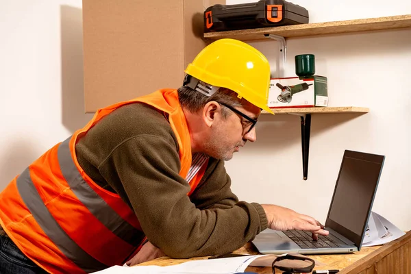 Caucasic Engineer checking laptop in work office. Concept of work organization.