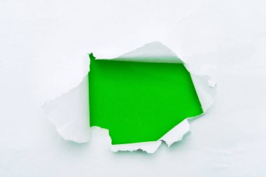 A hole in white paper with torn edges and a green isolated background inside, Ripped grenn and white paper, copy space