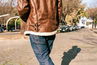An Unrecognizable man walking on his back. Only a portion of the back and legs are visible.