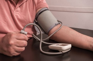 An Adult male taking his blood pressure. Healthy living concept, medicine, high blood pressure, attention, medical care,