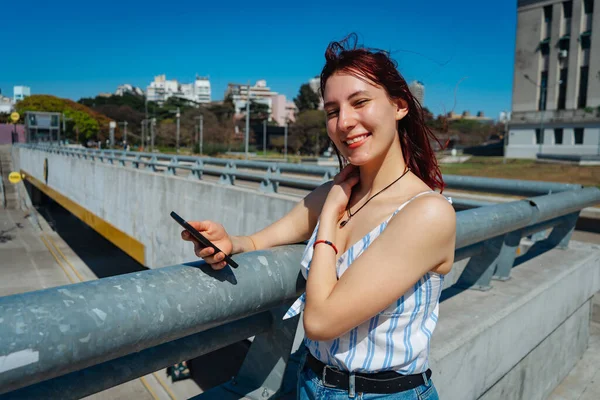 Een Jonge Roodharige Vrouw Die Berichten Bekijkt Haar Mobiele Telefoon — Stockfoto