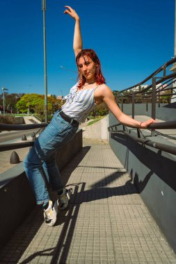 Sokaklarda zıplamalar ve taklalar atarak mutlu bir şekilde dans eden genç ve güzel Latin. Eğlence kavramı, sokak dansı, hip hop, gençlik.