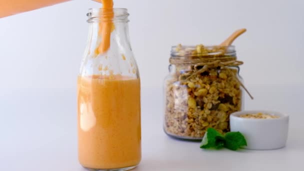 Powolny ruch Sezonowe dyniowe koktajle marchewkowe piją detoks wlewając do szklanej butelki eko metalową słomkę do picia. Śniadanie. Pomarańczowy smoothie. Czyste odżywianie, odchudzanie, zdrowa koncepcja diety — Wideo stockowe