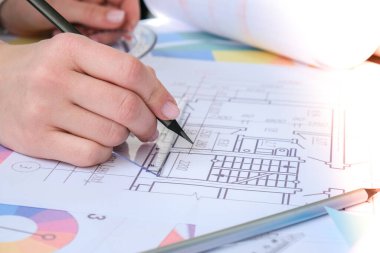 Eller kalemle açıölçer kullanır. Aletleri olan mimari proje çizimleri. Mimarlar işyeri. Mühendislik iç mimarının çalışma masası. Çalışma Alanı