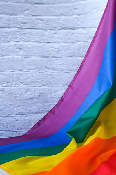 Rainbow flag on concrete background with copy space. Rainbow lgbtq flag made from silk material. Symbol of LGBTQ pride month. Equal rights. Peace and freedom. Support LGBTQ community