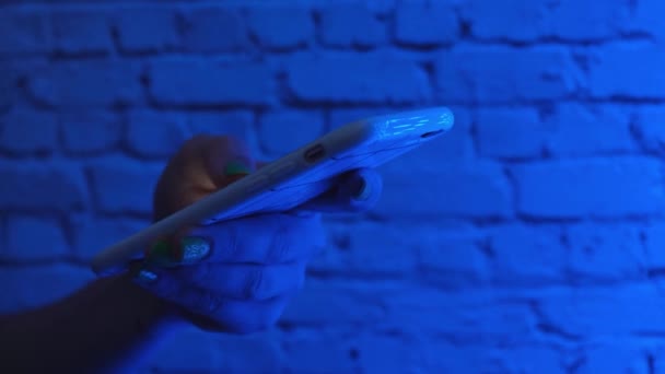 Kvinnliga händer med smart telefon på nära håll i trendiga neonljus på gatan. Livsstil. Lätt att betala nätbank med hjälp av smarttelefon eller digital enhet. Kommunikation via app till försäljning i butik. Sociala medier. 4k — Stockvideo