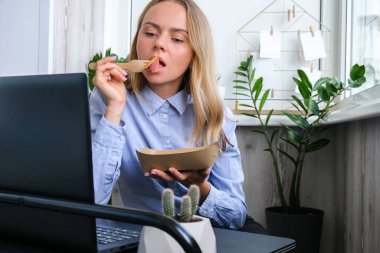 Sıfır öğle yemeği kutusunu elinde tutan kadın, sağlıklı kilo verme diyet menüsü olan yemek teslimat kutusu, iş yerinde vejetaryen yemeği. Ofis çalışanı çalışma yerinde vejetaryen yemeği yiyor.