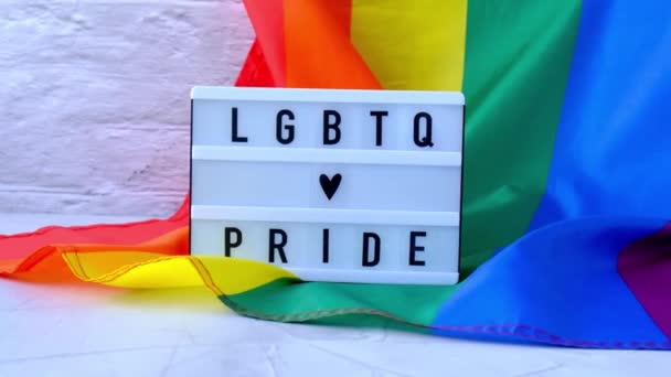 Işık kutulu 4k Gökkuşağı bayrağı ve LGBTQ PRIDE mesajı. İpek kumaştan yapılmış gökkuşağı lgbtq bayrağı. LGBTQ gurur ayının sembolü. Eşit haklar. Barış ve özgürlük — Stok video