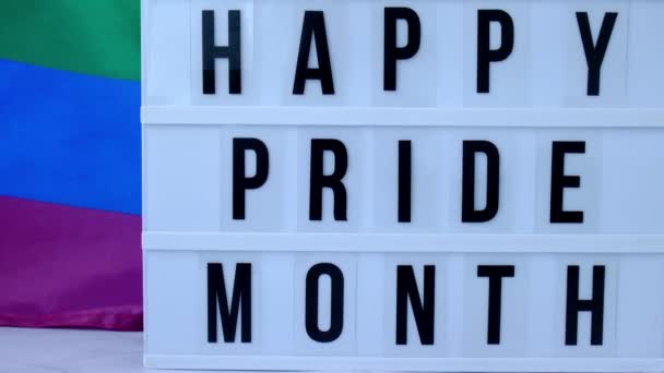 4kレインボーフラグライトボックスとテキストハッピープライドヶ月。シルク素材で作られたレインボーlgbtqフラグ。LGBTQプライド月間のシンボル。平等な権利。平和と自由 — ストック動画