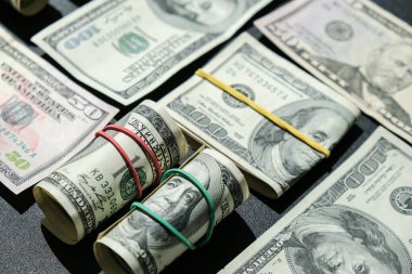Dolar arkaplanındaki izole edilmiş dolar destesi. Kağıt banknotlar, para ruloları ve lastik bantlar. Zenginlik ve refah finansmanı iş bütçesi. Amerikan dolarlarının yığın sermayesi nakit.