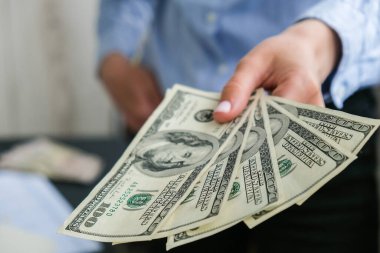 İş kadını, Amerikan dolarlarını sergiliyor. Yakın plan. Gelir ve İş Konsepti. Satış, rüşvet, yolsuzluk konsepti. El çabukluğu. Milenyum samimiyeti, otantik kadın elleri para sayıyor. Zenginlik ve refah iş bütçesi