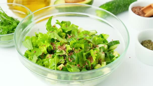 Mujer cocinando ensalada de verduras y hierbas verdes frescas. Cocinar una dieta saludable o comida vegetariana. Las manos femeninas añaden especias. Receta paso a paso. — Vídeo de stock