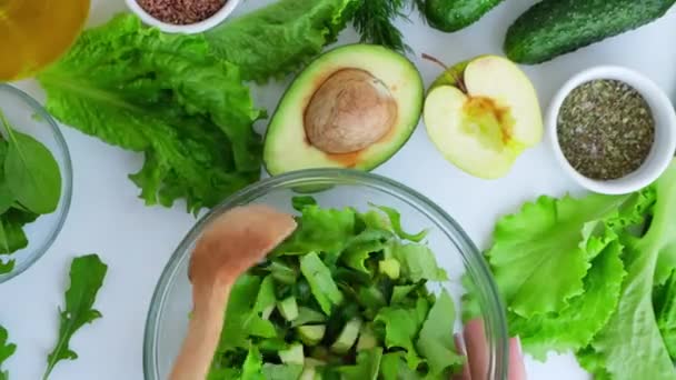 Frau mischt Salat mit frischem grünen Gemüse und Kräutern. Rohkost Konzept. Vegane Speisekarte. Gesunde Ernährung oder vegetarische Kost. Schritt für Schritt Rezept. — Stockvideo