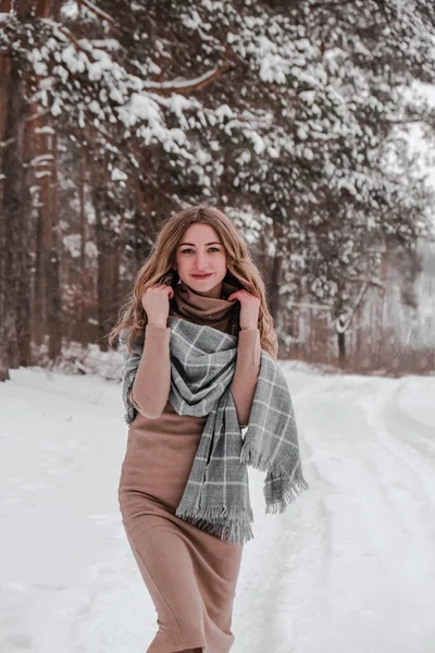 En lykkelig kvinne med vinterbakgrunn. Ung, pen jente ute i skogen. Portrett av en lystig, vakker kvinne. Vintermote. – stockfoto