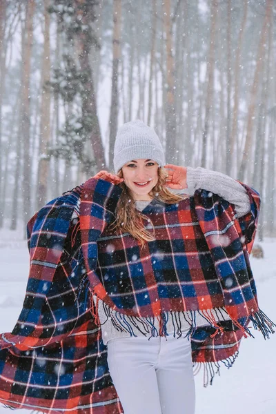 Dans eden kadın ormanda şapka ve panço giyerek geziyor, boho ve gezgin şehvet stili. Kış geliyor, ilk kar yağışı — Stok fotoğraf