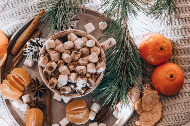 Sıcak kış kakaolu kupa ve yatakta mandalinalı ladin ladin dalıyla. Noel ışıkları. Çam kozalakları dekorasyonu. Sıcak kış günleri. Hygge.