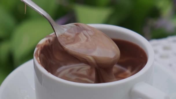 Copa de chocolate caliente en la mesa en la cafetería al aire libre verano. Hora del café y desayuno en el restaurante. Chocolate, leche espumosa caliente, cacao. — Vídeo de stock