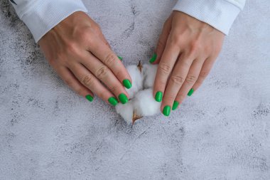 Manikürlü, yeşil tırnaklı kadın elleri. Modern moda tasarım manikürü. Jel tırnaklar. Cilt bakımı. Güzellik tedavisi. Tırnak bakımı. Sağlıklılık. Moda renkleri.