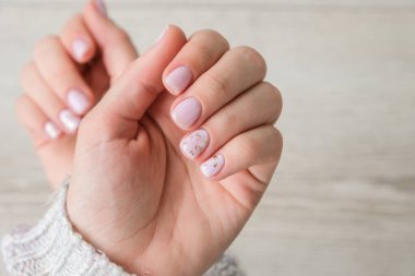 Yakın plan zarif pastel doğal modern tasarım manikürü. Kadın eli işte. Jel tırnaklar. Çıplak manikür. Bej rengi. Temiz cilt. Spa salonu, reklam. Cilt bakımı. Güzellik. Tırnak bakımı. Güzellik tedavisi. Boşluğu kopyala