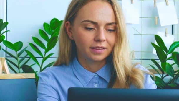 Junge Frau, die zu Hause am Computer arbeitet. Glücklich lächelnde Geschäftsfrau, die an ihrem Laptop arbeitet. Online-Nachhilfe für Konferenzen. Online-Bildungsstudentin — Stockvideo