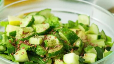 Taze yeşil sebze ve ottan salata pişiren bir kadın. Sağlıklı beslenme ya da vejetaryen yemekleri pişirmek. Kadın eli keten tohumu ekler. Adım adım tarif.