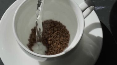 Barista evde kahve yapıyor. Beyaz Kupa Çikolatası 'na sıcak su dök. Taze Sabah Kahvenin üzerine dökülür Yakın çekim.