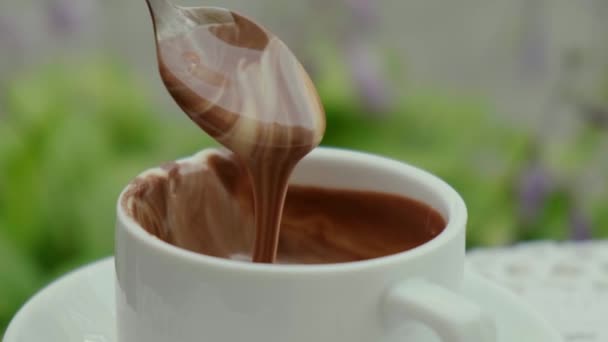 Copa de chocolate caliente en la mesa en la cafetería al aire libre verano. Hora del café y desayuno en el restaurante. Chocolate, leche espumosa caliente, cacao. — Vídeo de stock