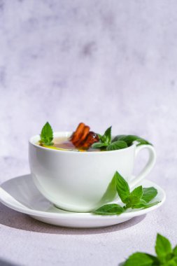 Limonlu siyah ve yeşil çay, tarçınlı çubuk ve nane yaprağı. Sıcak içecek. Sağlıklı Melissa çayı fincanda doğal organik aromatik içecek. Yaz, Sonbahar Kış Isınma İçeceği. Sağlıklı bitkisel çay.