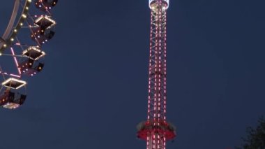 Odessa Ukrayna Temmuz 2021: aydınlatma tema parkı. Dönen atlıkarınca. Hızlı hareket eden parlayan dönme dolap. Gece vakti. Gece hayatı eğlencesi.
