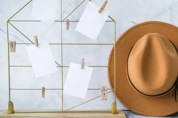 Cards and posters mock ups on grid board. Copy space. Feminine hipster office table decoration. Home office desktop. Freelance bloggers workplace. Cowboy hat decor