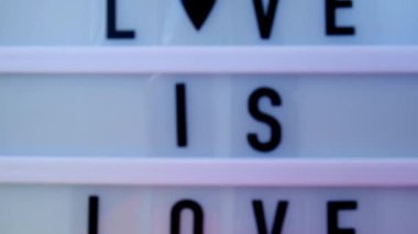 4k Gökkuşağı bayrağı ve ışık kutusu ve mesaj aşk aşktır. İpek kumaştan yapılmış gökkuşağı lgbtq bayrağı. LGBTQ gurur ayının sembolü. Eşit haklar. Barış ve özgürlük