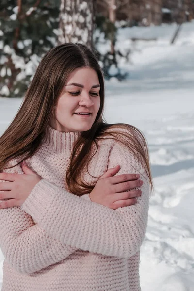 在冬季公园里穿着针织毛衣的年轻漂亮的女人.室外寒冷的天气。雪姑娘笑容可亲的画像 — 图库照片