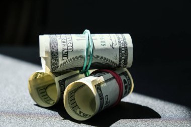 Dolar arkaplanındaki izole edilmiş dolar destesi. Kağıt banknotlar, para ruloları ve lastik bantlar. Zenginlik ve refah finansmanı iş bütçesi. Amerikan dolarlarının yığın sermayesi nakit.