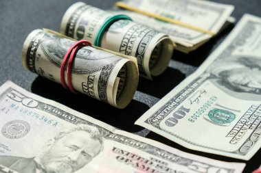 Dolar arkaplanındaki izole edilmiş dolar destesi. Kağıt banknotlar, para ruloları ve lastik bantlar. Zenginlik ve refah finansmanı iş bütçesi. Amerikan dolarlarının yığın sermayesi nakit.