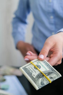 İş kadını, Amerikan dolarlarını sergiliyor. Yakın plan. Gelir ve İş Konsepti. Satış, rüşvet, yolsuzluk konsepti. El çabukluğu. Milenyum samimiyeti, otantik kadın elleri para sayıyor. Zenginlik ve refah iş bütçesi