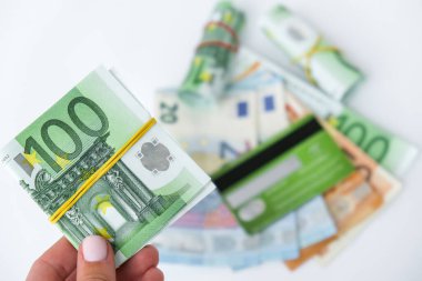 Avroyu yakından tutan kadın eli. Para birimi. Arka planda kredi kartı kartı kartı var. İnternetten alışveriş. Para vermek. Zenginlik ve refah finansmanı iş bütçesi, madeni para, ekonomi, döviz kuru