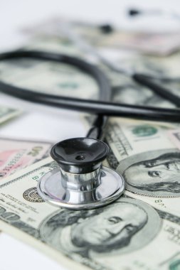 Bir yığın para ve steteskop. Tıbbi pahalı ilaç konsepti, doktor maaşı. Uzayı metin için kopyala. Sağlık sigortası. Aşı masrafları. Finansal kriz. Covid-19 suçları