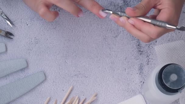 Vrouwelijke handen die manicure maken. Verwijdert nagelriemen Nagelverzorging, Zelfverzorging. Doe zelf manicure terwijl je thuis blijft. Sterf. Verf, vijl en ovale vorm nagels. — Stockvideo