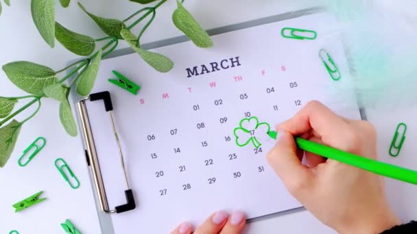 Kalender 17 maart. Heilige Patricks dag. Slim blad. Groene kleuren. Vrouwelijke hand planning vakantie. Plat gelegd. Bovenaanzicht. — Stockvideo