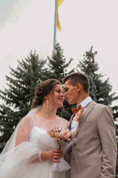 Sposo abbraccio e bacio sposa in palmeto. Il giorno del matrimonio per due. Bella coppia di diserbanti. Giovani amanti — Foto Stock