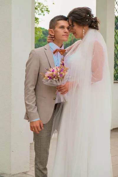 Sposo abbraccio e bacio sposa in palmeto. Il giorno del matrimonio per due. Bella coppia di diserbanti. Giovani amanti — Foto Stock