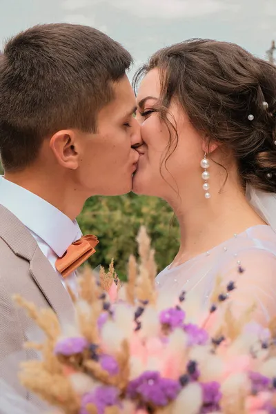 Sposo abbraccio e bacio sposa in palmeto. Il giorno del matrimonio per due. Bella coppia di diserbanti. Giovani amanti — Foto Stock