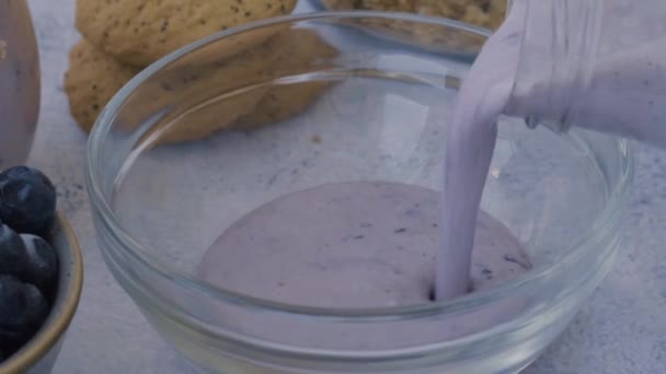 Frau bereitet gesunden Blueberry Smoothie mit Mixer zu. Mischung aus Frühstücksprotein-Smoothie-Getränk aus pürierten rohen Blaubeeren, Banane, Milch, Joghurt und Quark. — Stockvideo