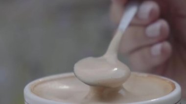 Kişi Eli Karıştıran Sıcak Çikolata. Taze Sabah Kahvesi. Yakın çekim. Beyaz Kupada Latte cappuccino. Bir fincan aromatik kahveye şeker karıştırır.