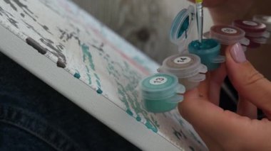 Kadın elleri tuvali boyuyor. Yaratıcı bir hobi. Yeni başlayanlar için resim yapmak. Evde kilitli kalmak için boş zaman aktivitesi, stres önleyici bir fikir. Meditasyon, rahatlama konsepti