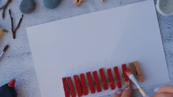 用白色背景的鹅卵石、海石、衣针和树枝制成的明信片，在贺卡上写上迪伊 · 梅里圣诞鹿。自然生态风格的迪伊。礼物的主意。一步一步。顶部视图. — 图库视频影像