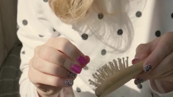Hand houdt een bos haar op de kam. Haaruitval concept. Vrouwelijke seizoensgebonden haaruitval problemen. Alopecia haaruitval behandeling. — Stockvideo