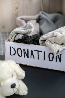 İçinde eski oyuncaklar ve giysiler olan bir bağış kutusu. Hayırseverliğin kutlu olsun. İçinde giysiler olan bir kutu. Yakın plan. Kıyafet bağışı. Karton kutuda kışlık giysiler.