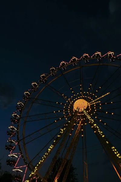 Ferris Wheel Lights τη νύχτα. Νέον χρωματιστά φώτα αναβοσβήνουν στον τροχό. Πάρκο διασκέδασης τη νύχτα. Διασκέδαση και διασκέδαση. Carousel αναψυχής στο καρναβάλι. — Φωτογραφία Αρχείου