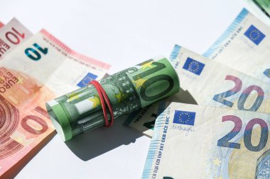 Euro para akışını kapat. Euro banknotu nakit para belirledi - AB para birimi. Lastik euro banknotlarıyla sarılmış. Banknotlar farklı pozisyonlarda üst üste dizilmiş